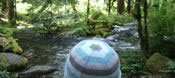 picture of hatted, seated friend gazing at mckenzie river, oregon